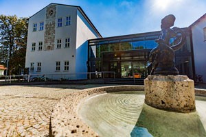 Heinrich-Braun-Grundschule in Trostberg mit dem Fischbuberl-Brunnen im Vordergrund