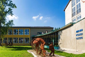 Das Foto zeigt die Mittelschule Trostberg von der Heinrich-Braun-Straße aus. Skulpturen der Kunstmeile schmücken das Gebäude.