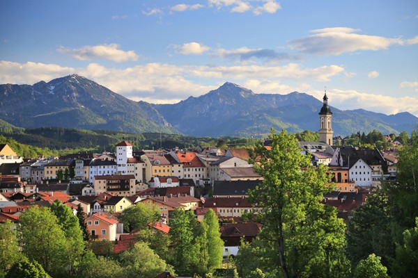 Das Foto zeigt die Stadt Traunstein. Dahinter sieht man ein Bergpanorama.