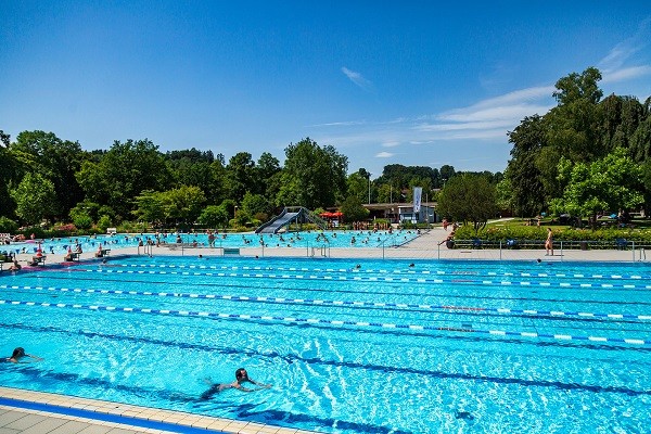 Das Schwimmerbecken mit dem Nichtschwimmerbecken und der Rutsche im Hintergrund