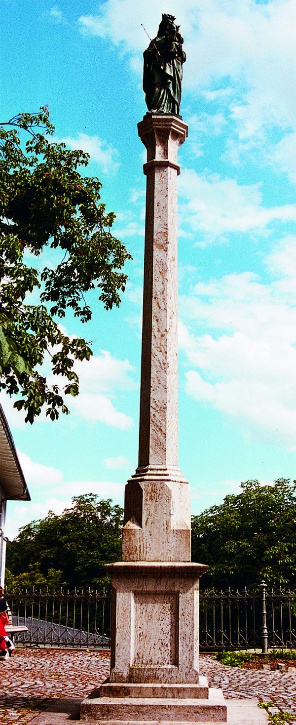 Das Foto zeigt eine Steinsäule mit der Heiligen Maria an der Spitze.