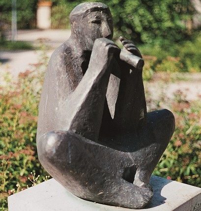 Das Foto zeigt die Skulptur eines sitzenden Flötenspielers von Marianne Lüdicke, 1987.