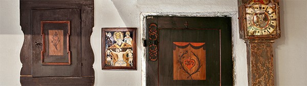 zwei Bilder, eine alte Holztür und eine Standuhr der Bauernstube