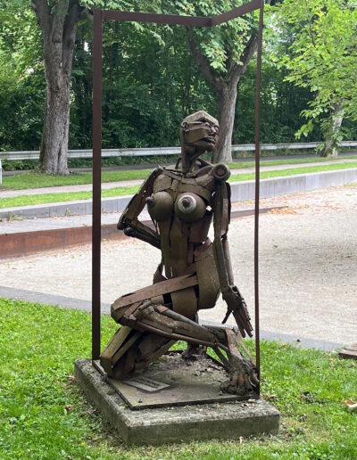 ESCHENBACHER, Andreas: „Um die Ecke/Nackte Frau knieend“, 2013, Cortenstahl. Begegnungsplatz, Jahnstraße