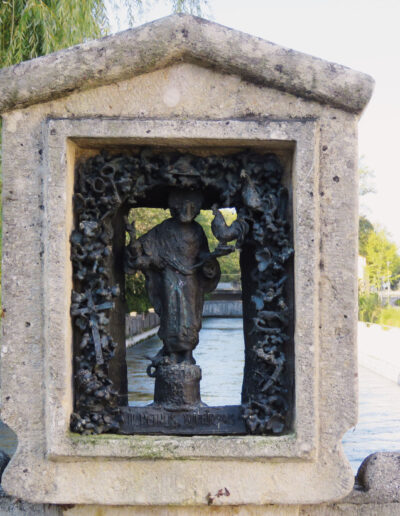 NEUSTIFTER, Josef: „St. Petrus“, 1990, Stein und Bronzeguss. Ziegelauer Steg („Brezensteg“) am Alzkanal, Kanalstraße