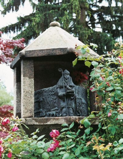 SCHMIDT, Dieter: „Severus“, 2000, Stein und Bronzeguss, Bischof von Ravenna, Mitte 4. Jahrhundert, Schutzpatron der Papier-, Tuch-, Handschuh- und Hutmacher und Polizisten. Traunsteiner Straße 16