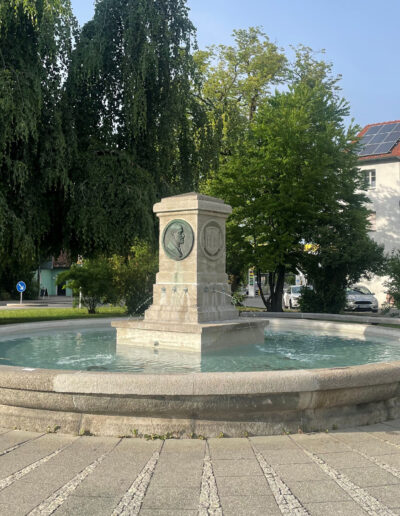 UNBEKANNT: „Caro-Brunnen“, 1931, Stein und Bronzeguss, errichtet zu Ehren von Dr. Nicodem Caro, dem Mitbegründer der Kalkstickstoff-Industrie. Caroplatz